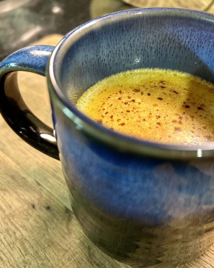 a blue mug of golden milk up close