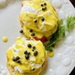 eggs Benedict with hollandaise sauce plated on a white plate