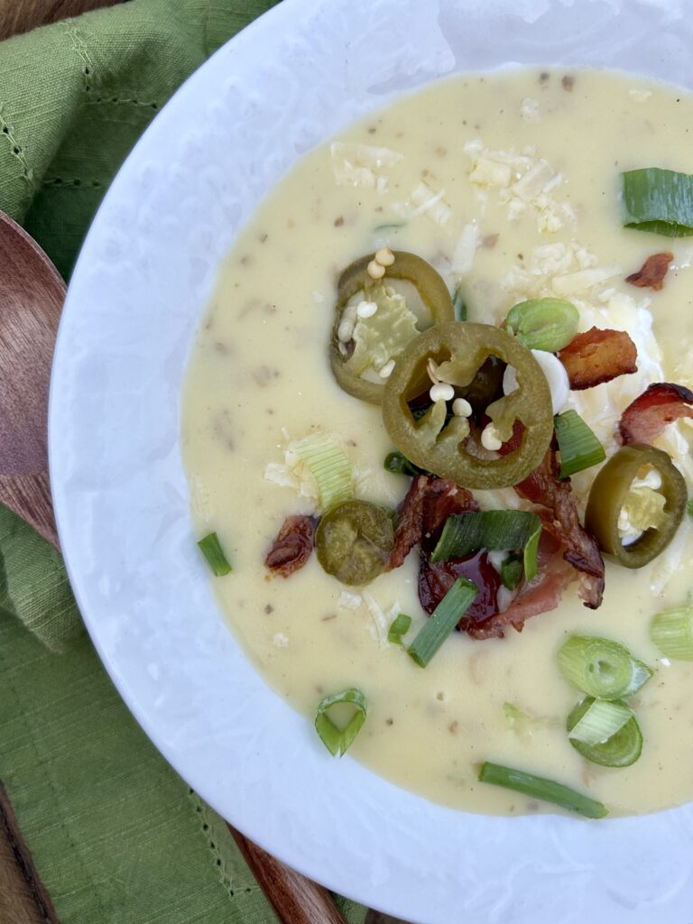 An up-close bowl of loaded baked potato soup with all the toppings.