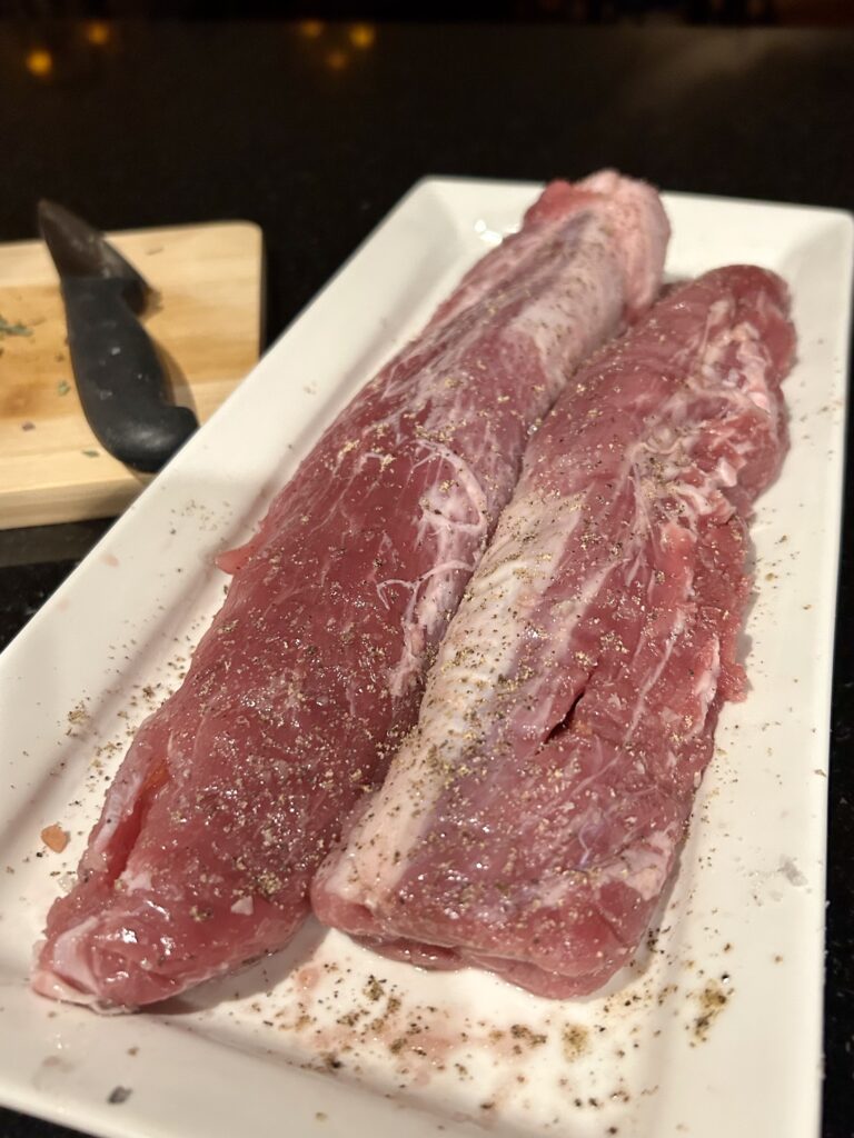 2 pork loins on a plate with salt and pepper