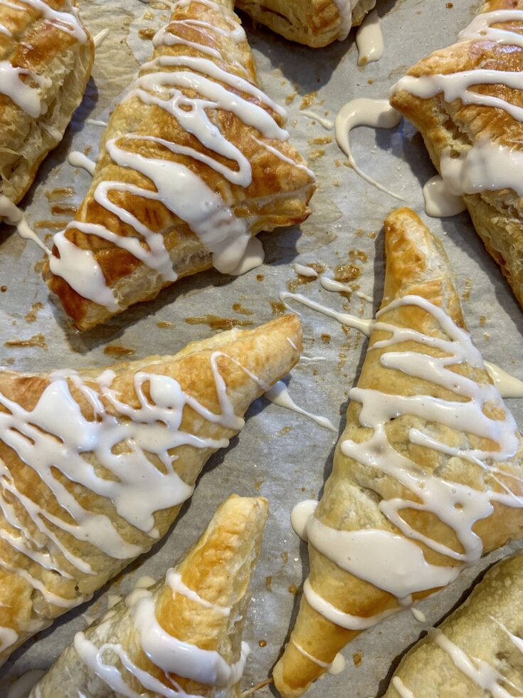 a tray of finished glazed apple turnovers