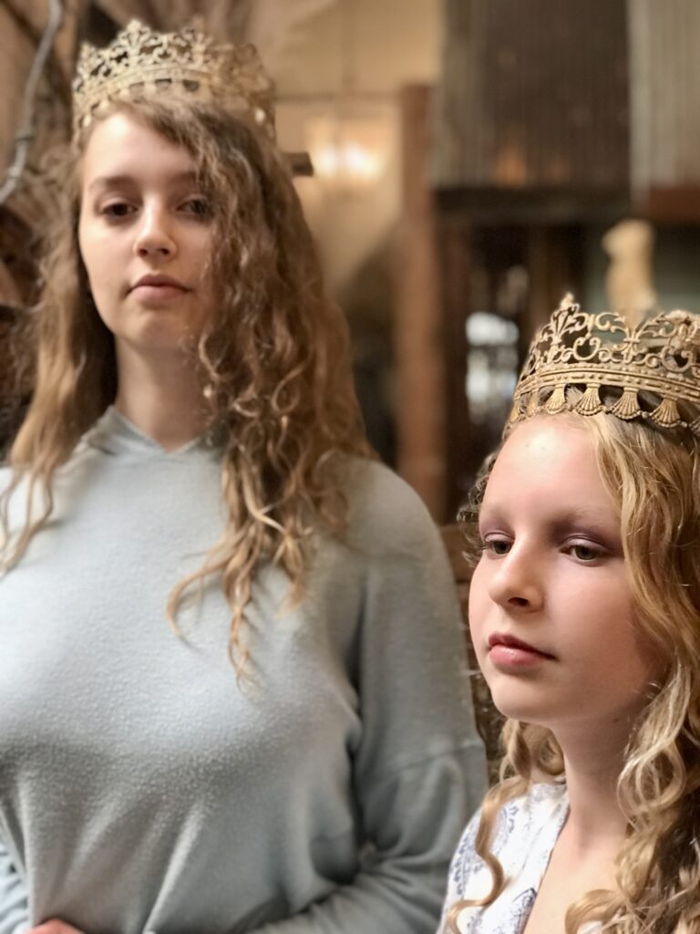 two girls wearing crowns revealing identity